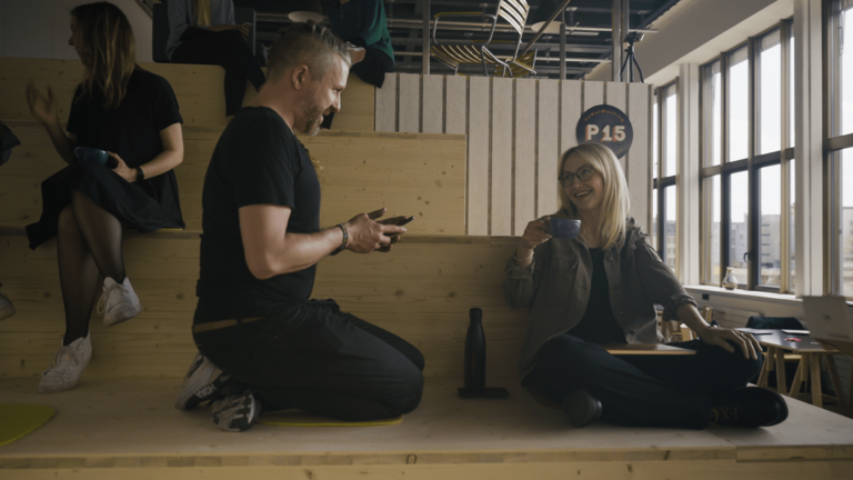 Die Mitarbeiter:innen der Agentur Die Schwedin. sitzen auf der Treppe im Co-Working und machen eine Kaffeepause.